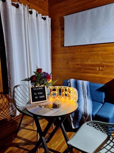 a living room with a table and a blue couch at Ecoverso Cabañas del bosque in Medellín