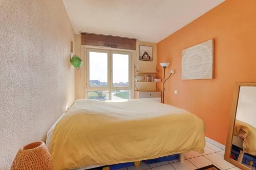 une chambre avec un lit et une grande fenêtre dans l'établissement Le Parnasse : T2, vue sur le Lez, tram à proximité, à Montpellier