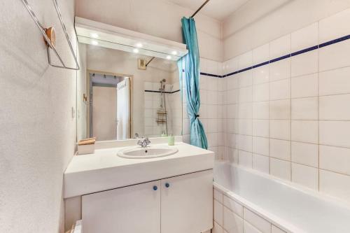 La salle de bains blanche est pourvue d'un lavabo et d'une baignoire. dans l'établissement Le Parnasse : T2, vue sur le Lez, tram à proximité, à Montpellier