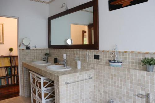 La salle de bains est pourvue de 2 lavabos et d'un grand miroir. dans l'établissement Villa Bano Piemonte Private Pool, à Melazzo