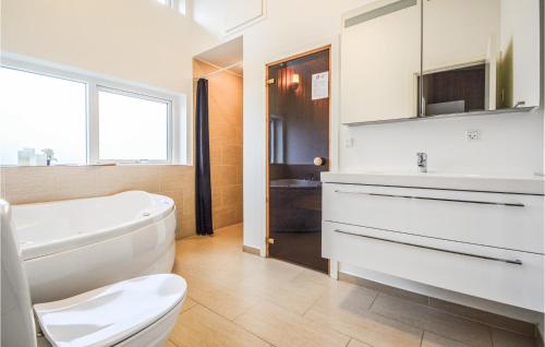 a white bathroom with a toilet and a sink at Beautiful Home In Haderslev With 4 Bedrooms, Sauna And Wifi in Årøsund