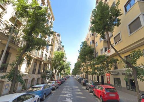 a street with cars parked on the side of the road at Casa Luna, tu oasis en mejor barrio de Madrid in Madrid
