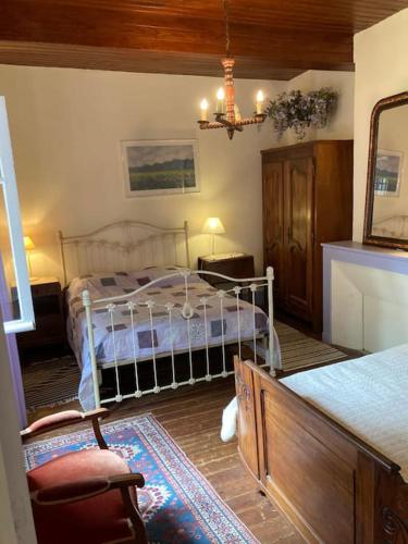 une chambre avec un lit et une chaise dans une pièce dans l'établissement maison de campagne avec grand lac et park arboré, à Montestruc-sur-Gers
