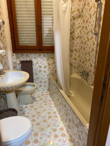 a bathroom with a toilet and a tub and a sink at Nuovo Hotel Attico in Chianciano Terme