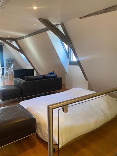 - une chambre mansardée avec un lit et un canapé dans l'établissement DUPLEX 15, à Colmar