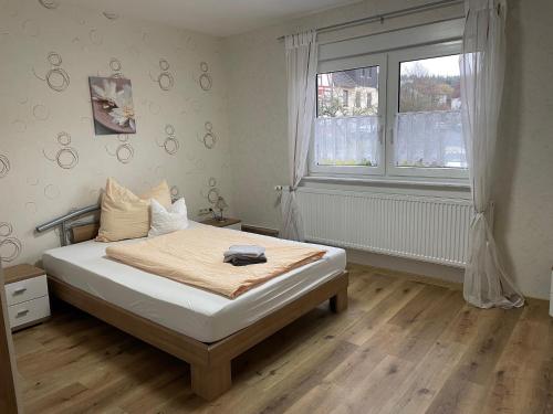 a bedroom with a bed and a large window at Zum Bergschlösschen in Gilserberg