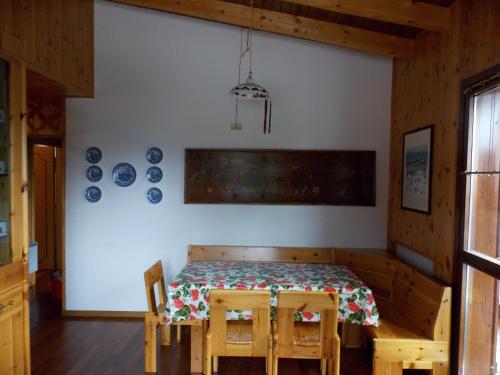 a dining room with a table and some plates on the wall at Nevi Apartment in Folgarida