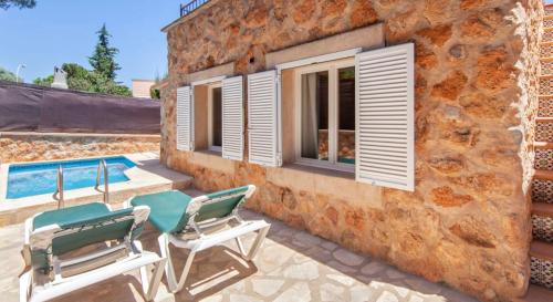 een patio met 2 stoelen en een zwembad bij Casa Piedra Mallorca in El Toro