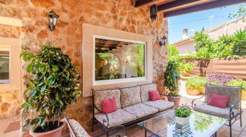 een patio met stoelen en een bank op een stenen muur bij Casa Piedra Mallorca in El Toro