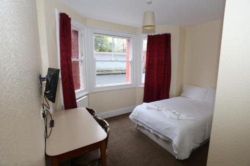 Habitación pequeña con cama y ventana en Charlie Hotel, en Londres