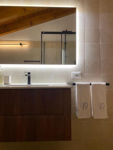 a bathroom with a sink and a mirror and towels at Residence19ilborgo in Asolo