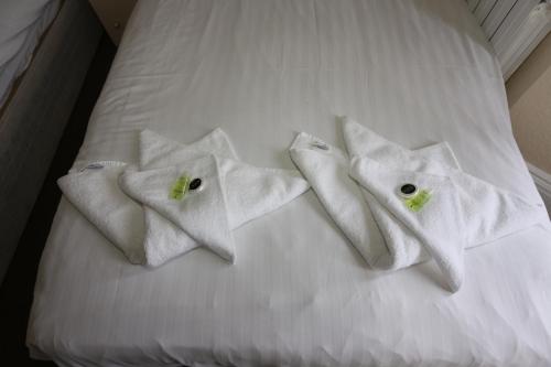 3 toallas blancas en una cama blanca en Charlie Hotel, en Londres