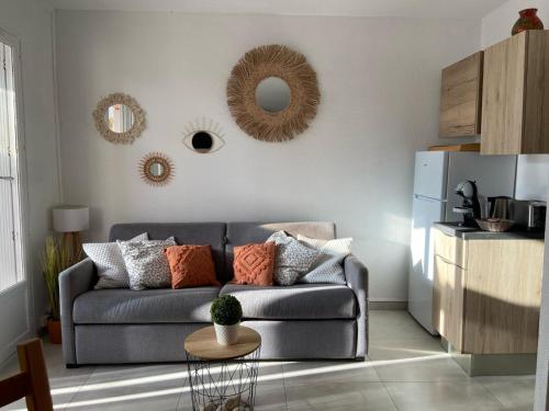 - un salon avec un canapé et des miroirs sur le mur dans l'établissement La terrasse bandolaise tout à pied, wifi, clim, parking, à Bandol