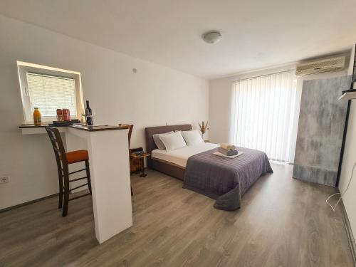 a bedroom with a bed and a table with a chair at Lemon&Olives in Budva