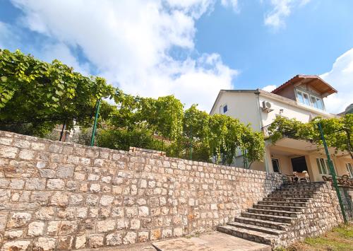 a stone retaining wall with stairs in front of a house at Lemon&Olives in Budva