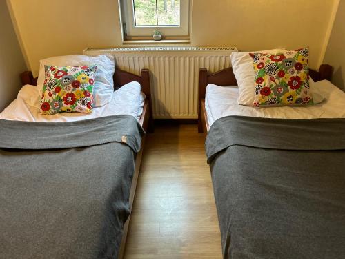 two beds in a small room with sidx sidx sidx at Domek w Lesie in Karłów