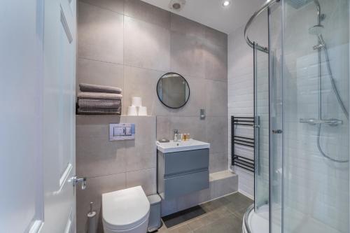 ein Bad mit einer Dusche, einem WC und einem Waschbecken in der Unterkunft Kula London - Tower Bridge in London
