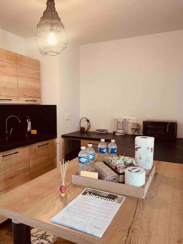 une cuisine avec une table et des bouteilles d'eau. dans l'établissement Appartement 2 chambres cosy proche aéroport et MEETT au pied du tram, à Blagnac