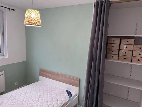 una piccola camera con letto e lampadario a braccio di « Le City » proche aéroport CDG, Parc Astérix, Disney, a Dammartin-en-Goële