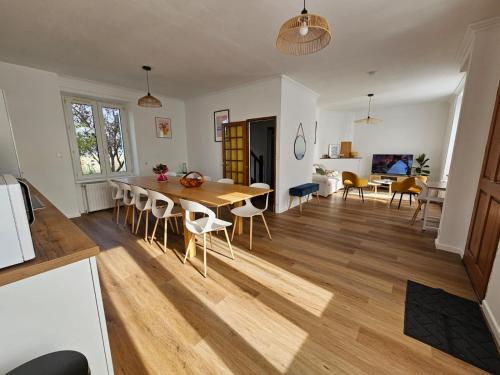 een keuken en een woonkamer met een houten tafel en stoelen bij Chambre lumineuse en coloc in Ploërmel