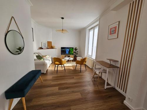 een woonkamer met een tafel en stoelen en een spiegel bij Chambre lumineuse en coloc in Ploërmel