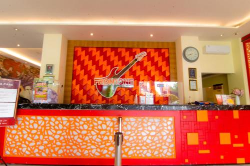 a front counter of a food store with a guitar on the wall at Front One Hotel Purwodadi in Purwodadi