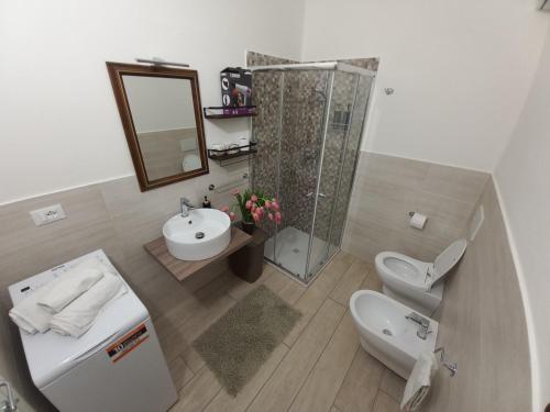 ein Bad mit einer Dusche, einem Waschbecken und einem WC in der Unterkunft Il Melograno casa vacanze in Teulada