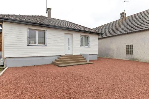 a white house with a porch and stairs in front at Au Doux Refuge - Maison - Parking gratuit in Romorantin