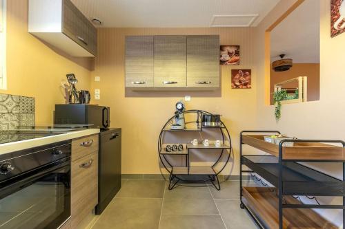 une cuisine avec un comptoir et une chaise dans l'établissement Au Doux Refuge - Maison - Parking gratuit, à Romorantin-Lanthenay