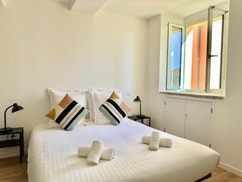 a white bedroom with a large white bed with two pillows at Sicardi 2 - Plage - Climatisation in Menton