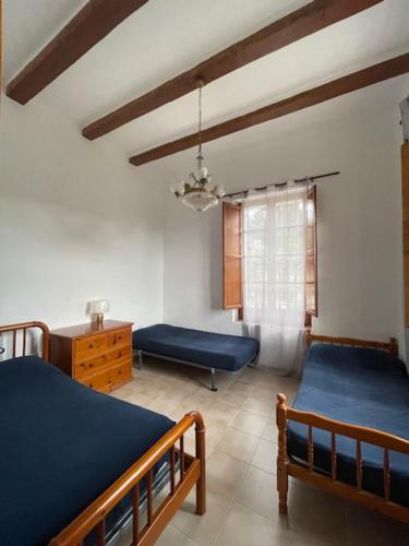 a bedroom with two beds and a table and a window at La Muntanya alojamiento rural turistico vacacional in Tortosa