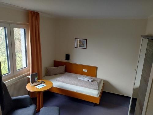 a small bedroom with a bed and a table at Pension Stocker in Dierhagen