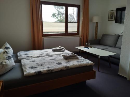 a room with a bed and a couch and a table at Pension Stocker in Dierhagen