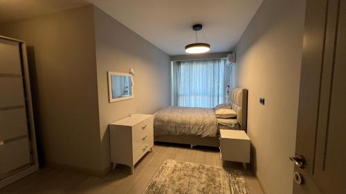 Habitación pequeña con cama y ventana en Luxury Apartment -Es, en Sarıyer
