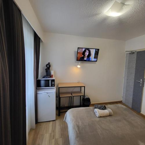 a room with a bed and a tv on the wall at GA location in Mâcon