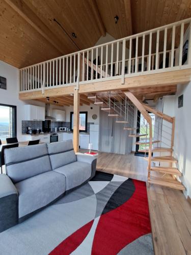 a living room with a couch and a staircase at Chalet dans les Hautes- Pyrénées entre Lourdes et Bagnères Calme et Vue magnifique in Arrodets-ez-Angles