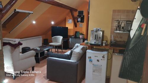 a living room with a couch and a kitchen at Fly in Dobanovci