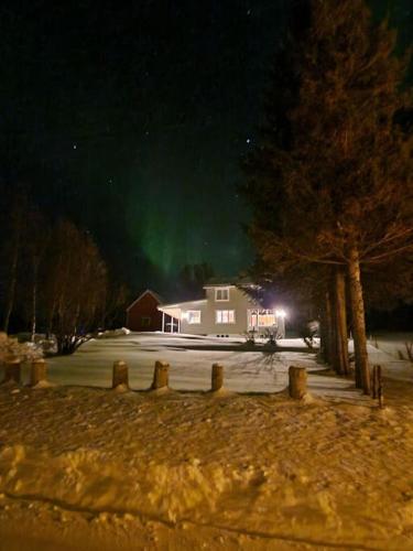 a house with the aurora in the sky at night at Arctic Cabin Lyngen in Svensby