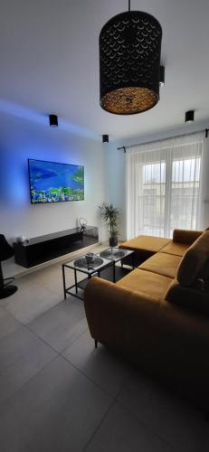 a living room with a couch and a flat screen tv at Apartament JB 56m2 parking,balkon,2sypialnie in Legnica