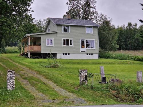 a house sitting on top of a lush green field at Arctic Cabin Lyngen in Svensby