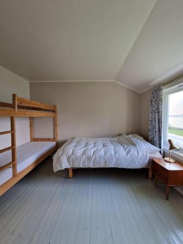 a bedroom with two bunk beds and a window at Arctic Cabin Lyngen in Svensby