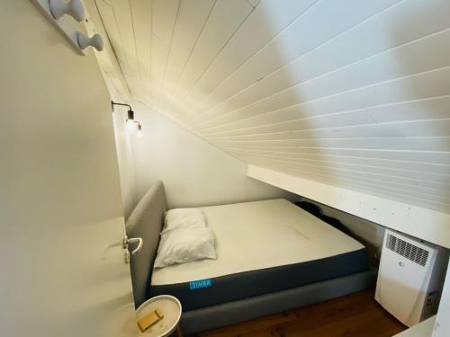 uma pequena cama num pequeno quarto com uma janela em Maisonnette dans la verdure et le calme em Pornichet