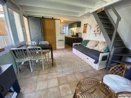 Cette petite chambre comprend des lits superposés, une table et des chaises. dans l'établissement Tiny House dans la verdure et le calme, à Pornichet