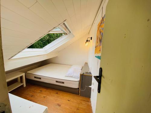 um pequeno quarto numa pequena casa com uma janela em Maisonnette dans la verdure et le calme em Pornichet