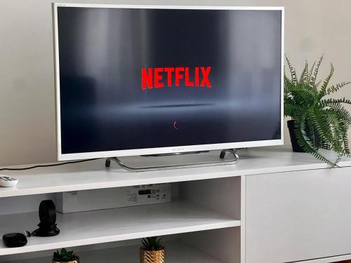 a television on a white shelf with a netflix sign on it at Luxus Apartment in Vienna