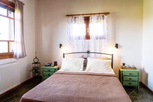 a bedroom with a bed with a curtain and a window at Jutta's house in Kallithéa