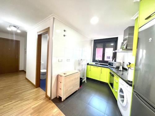 eine Küche mit grünen Schränken, einer Waschmaschine und einem Trockner in der Unterkunft Apartamento Carril in Vilagarcia de Arousa