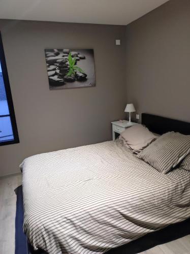 une chambre avec un lit et un tableau au mur dans l'établissement Chambre chez l'habitant, à Coutances