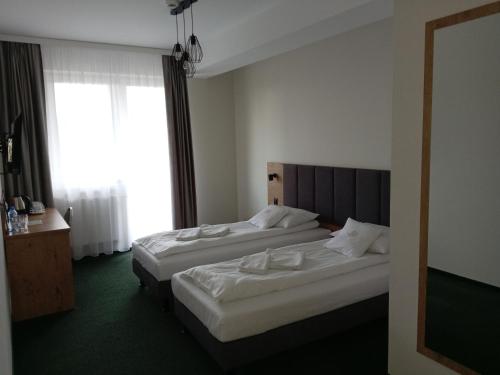 a hotel room with two beds and a window at Karczma u Jana in Kuczów