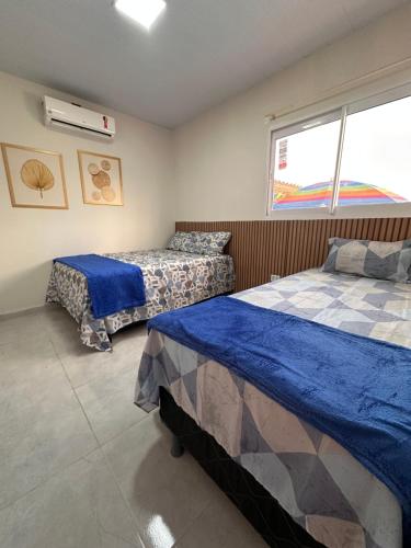 een slaapkamer met twee bedden en een raam bij Bela Beach in São José da Coroa Grande